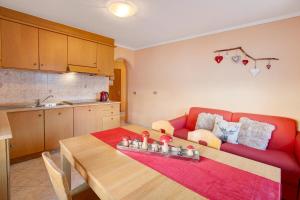 a living room with a red couch and a table at Lovin Winter in Livigno