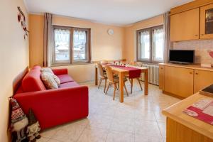 a living room with a red couch and a table at Lovin Winter in Livigno