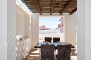 a dining room with a glass table and chairs at Villa Canijo in Barbate