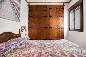 a bedroom with a bed with a large wooden door at Villa Canijo in Barbate