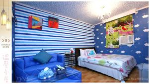 una camera con un letto e un divano blu di Genial House a Jiaoxi