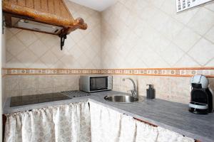 a small kitchen with a sink and a microwave at Villa Canijo in Barbate +12 photos