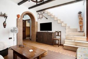 a living room with a staircase and a tv at Villa Canijo in Barbate