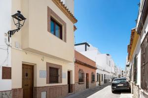 a street with buildings and a car parked on the street at Villa Canijo in Barbate