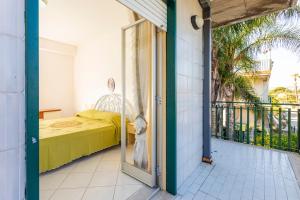 a room with a bed and a glass door at I Ciottoli Dello Ionio in Mascali