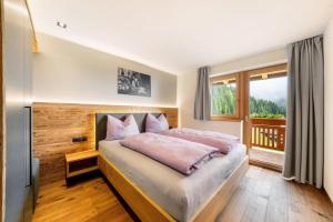 a bedroom with a bed and a large window at Oberhaushof in Santa Valpurga
