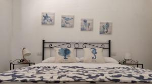 a bedroom with a bed with four pictures on the wall at Lazulite - Sardinia Suite in Murta Maria +17 photos