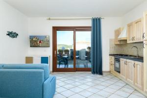 a living room with a blue couch and a kitchen at Lazulite - Sardinia Suite in Murta Maria