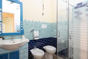 a blue tiled bathroom with a toilet and a sink at Casa Sole in Dorgali