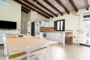 a large kitchen with a wooden table and chairs at Casa Sole in Dorgali +14 photos