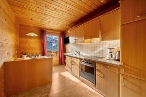 a kitchen with wooden cabinets and a sink and a stove at Thalhof Laugen in Ultimo