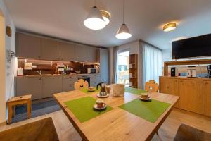 a kitchen with a wooden table with chairs and a tableablish at Gass Apartment A in Laion