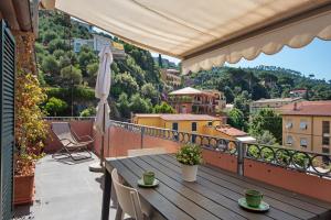 a table on a balcony with a view of a city at La terrazza di via Daneri 2 in Bonassola