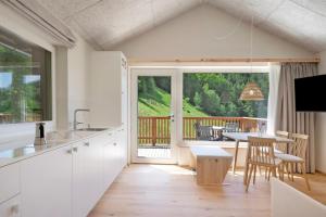 a kitchen with a table and a view of a deck at Höllerhof in Cornedo all'Isarco