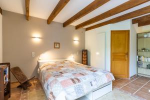 a bedroom with a bed in a room with wooden ceilings at Chambre Millepertuis in Auriac-du-Périgord