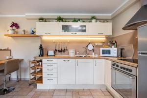 a kitchen with white cabinets and a sink at Ferienwohnung Fasse in Uslar