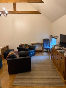 a living room with two couches and a tv at Ystrad Fach Farm in Llangendeirne +11 photos