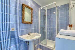 a blue tiled bathroom with a sink and a shower at Mas des Cypres - Mazet 7 in Saintes-Maries-de-la-Mer