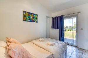 a bedroom with a bed and a sliding glass door at Mas des Cypres - Mazet 7 in Saintes-Maries-de-la-Mer
