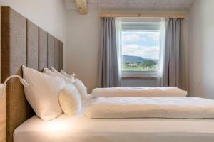 two beds in a room with a window at Höllerhof in Cornedo all'Isarco