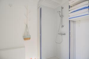 a shower in a bathroom with white walls at La Cabane des Goélands Rieurs in Dinard +11 photos