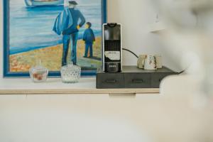 a bathroom shelf with a hair dryer and a painting at La Cabane des Goélands Rieurs in Dinard