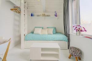 a small room with a bed in a window at La Cabane des Goélands Rieurs in Dinard