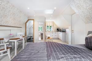 a bedroom with a bed and a table and a kitchen at My Little Rose Cottage in Dörpling
