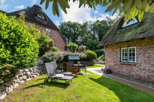 a garden with chairs and a house at My Little Rose Cottage in Dörpling
