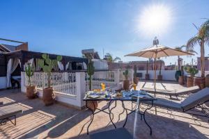 a patio with a table and an umbrella at Riad Lalla Azalay in Marrakesh