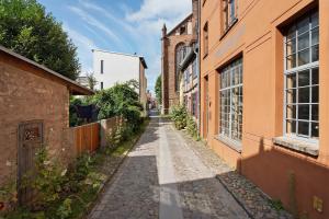 an alley in an old town with orange buildings at Alte Seifensiederei - Ferienloft in Stralsund
