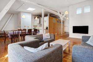 a living room with two couches and a dining room at Alte Seifensiederei - Ferienloft in Stralsund