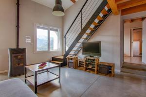 a living room with a tv and a staircase at Gîte Ludomi in Vercheny