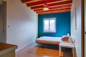 a bedroom with blue walls and a bed with a window at Gîte Ludomi in Vercheny
