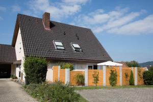 a house with a black roof and a fence at Ferienwohnung Dr Saretz in Bodman