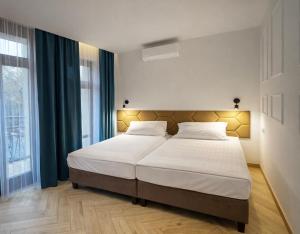 a bedroom with a large bed with white sheets at Willa Deptak in Krynica Zdrój +17 photos