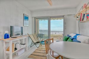 a living room with a table and a desk with a view at Appartement front de mer - Terrasse in Pornichet