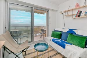 a living room with a couch and a balcony at Appartement front de mer - Terrasse in Pornichet