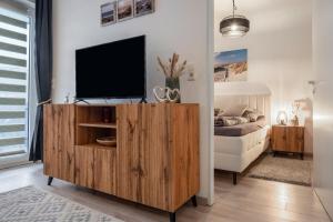 a living room with a television on a wooden entertainment center at Fewo Seehase in Dorum-Neufeld