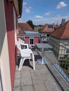 a white chair and a table on a balcony at Ferienwohnung Beck in Ansbach +5 photos