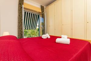 a bedroom with a red bed with towels on it at I Ciottoli Dello Ionio in Mascali +288 photos