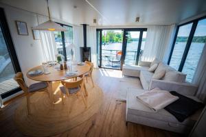 a living room with a table and a couch at Exklusives Hausboot Pina Woma D13 in Fürstenberg