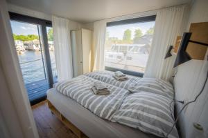 a bedroom with a bed and a window with a boat at Exklusives Hausboot Pina Woma D13 in Fürstenberg
