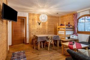 a dining room with a table and a tv at Dolomitc Tobià in Campitello di Fassa