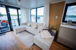 a living room with a couch and a view of the water at Exklusives Hausboot Pina Woma D13 in Fürstenberg