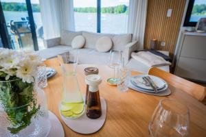 a wooden table with wine glasses and a vase of flowers at Exklusives Hausboot Pina Woma D13 in Fürstenberg +8 photos