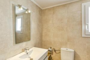 a bathroom with a sink and a toilet and a mirror at Escala Riells in L'Escala
