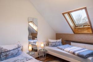 a attic bedroom with two beds and a skylight at Ferienwohnung Schiller in Grebenhain +23 photos