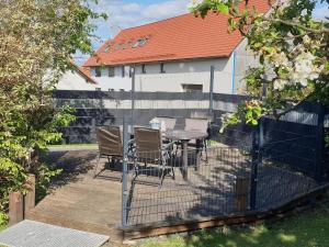 a patio with a table and chairs and a fence at Ferienwohnung Schiller in Grebenhain