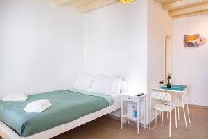 a white bedroom with a bed and a desk at Irene's Studio in Mikonos +16 photos